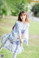 A woman in a blue and white kimono is posing for a picture.