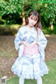 A young woman in a blue and white kimono posing for a picture.