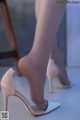 A close up of a woman's legs wearing high heels.