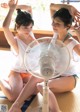 Two young women sitting on the floor next to a fan.