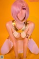 A woman with pink hair and a gold necklace.