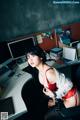 A woman sitting at a desk in front of a computer.