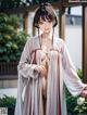 A woman in a kimono standing in front of a building.