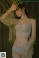 A woman in a white lingerie posing for a picture.