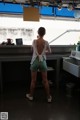 A woman standing in front of a sink in a kitchen.