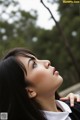 A woman with long black hair and a white shirt.